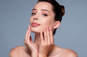 Lovely pretty girl enjoy her flawless face skin after moisturizing mask isolated on grey color background